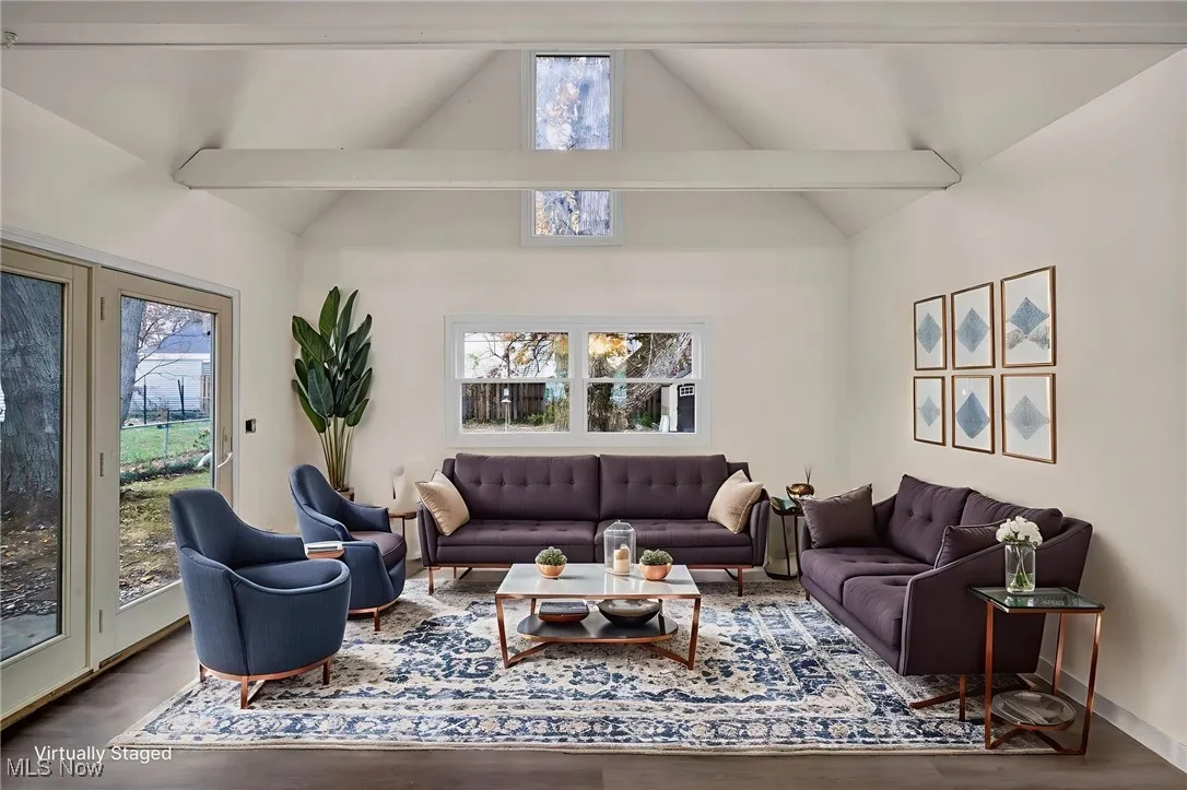 Living area featuring beam ceiling, wood finished floors, and high vaulted ceiling