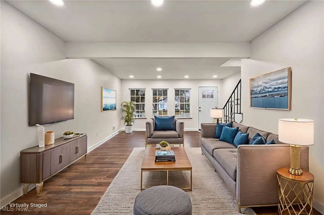 Living area featuring recessed lighting, wood finished floors, and stairway