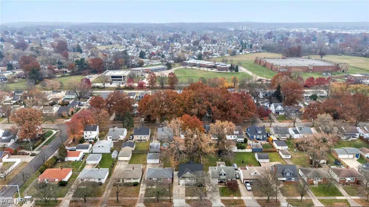 Aerial view of property and surrounding area featuring nearby suburban area