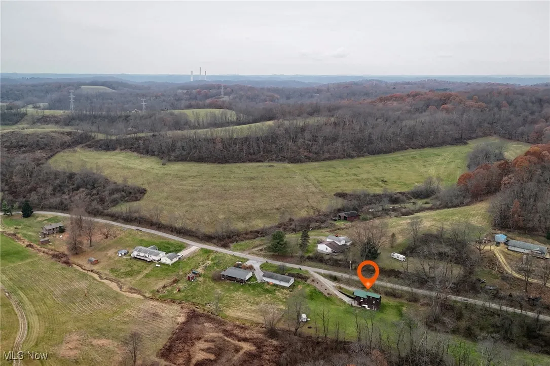 Aerial view of property and surrounding area featuring a heavily wooded area