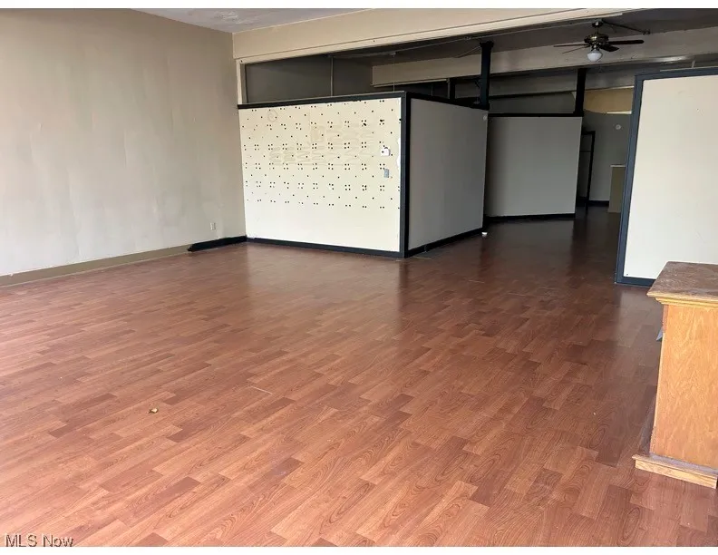 Empty room with dark wood-style floors and ceiling fan