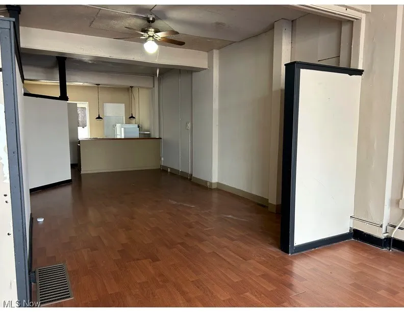 Unfurnished living room with ceiling fan and dark wood finished floors