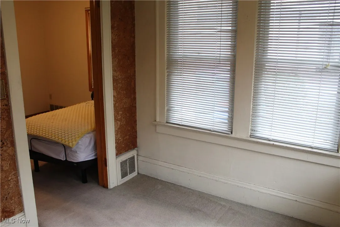 Sunroom looking into dining room featuring carpet and baseboards