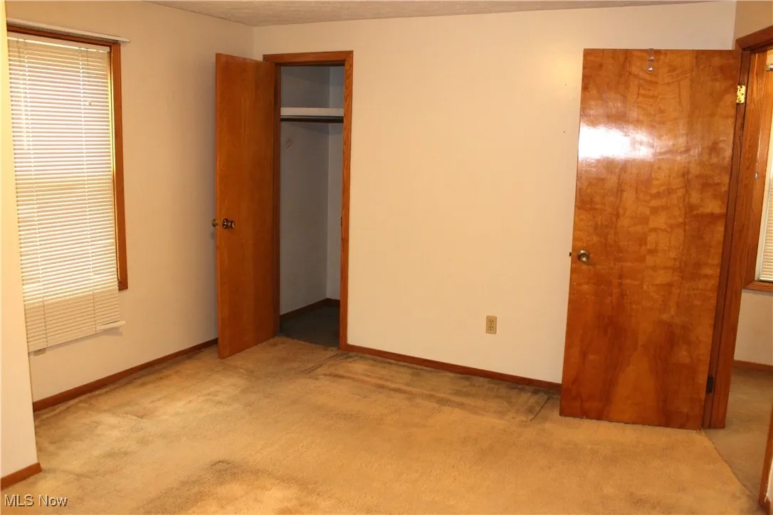 Bedroom featuring light carpet and a closet