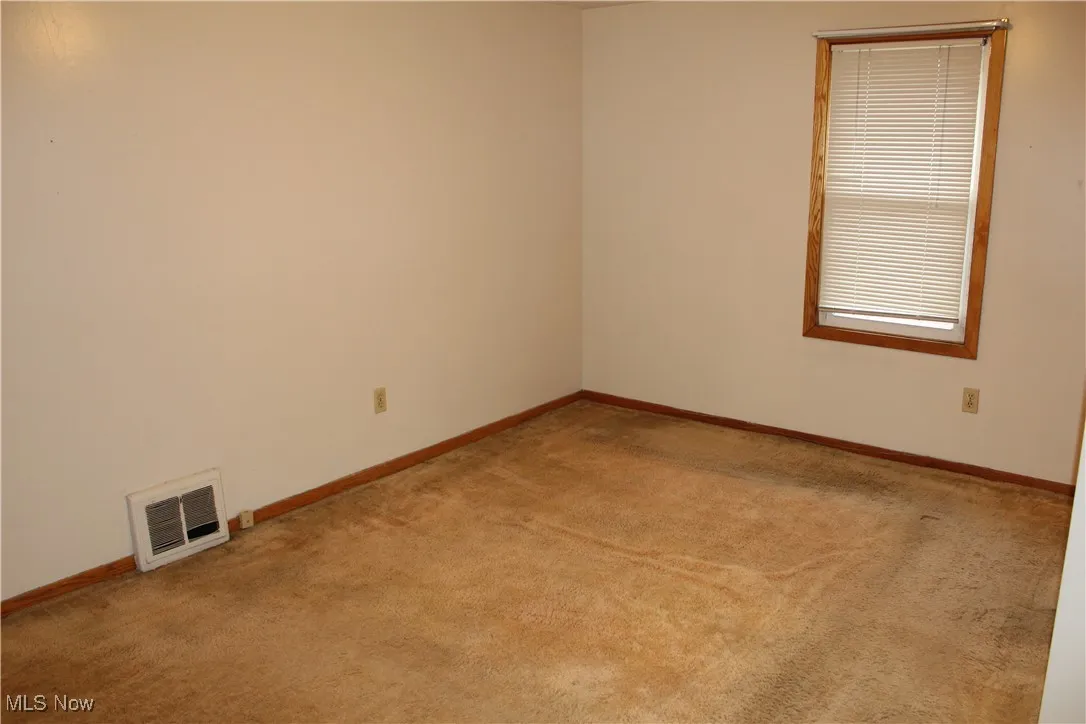 Bedroom featuring light carpet and baseboards