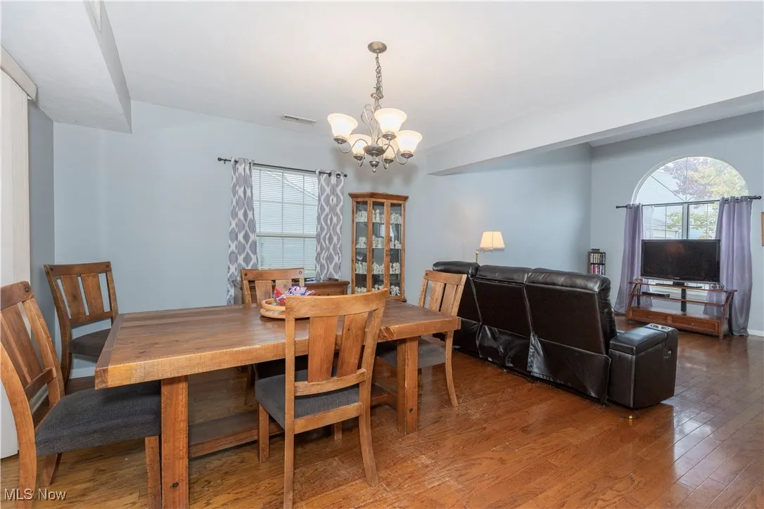 Dining area with wood finished floors, plenty of natural light, and a chandelier