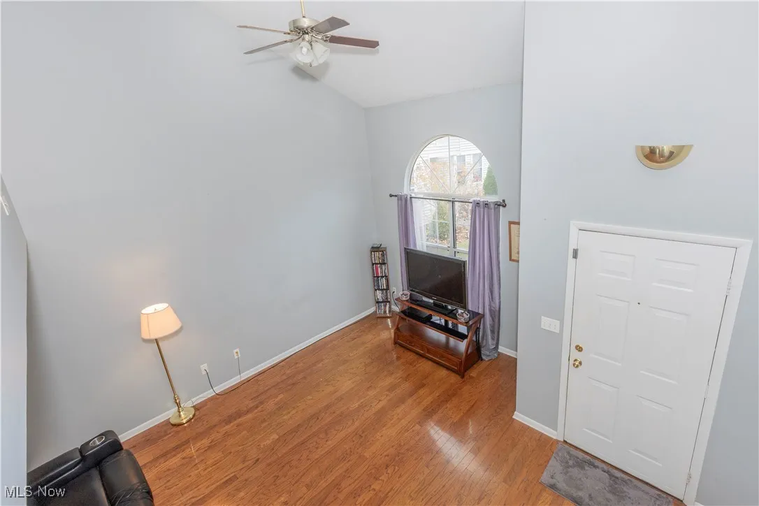 Entrance foyer with wood finished floors, a ceiling fan, and vaulted ceiling