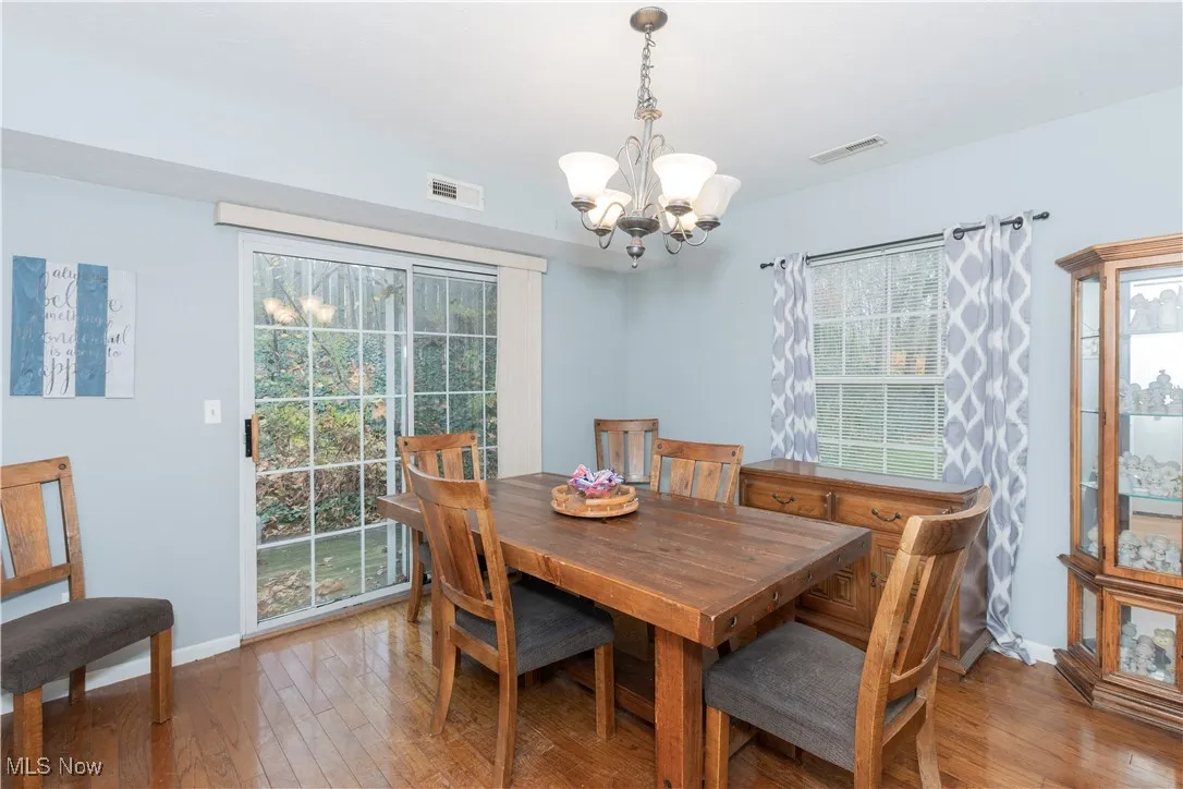 Dining space with wood-type flooring and a chandelier