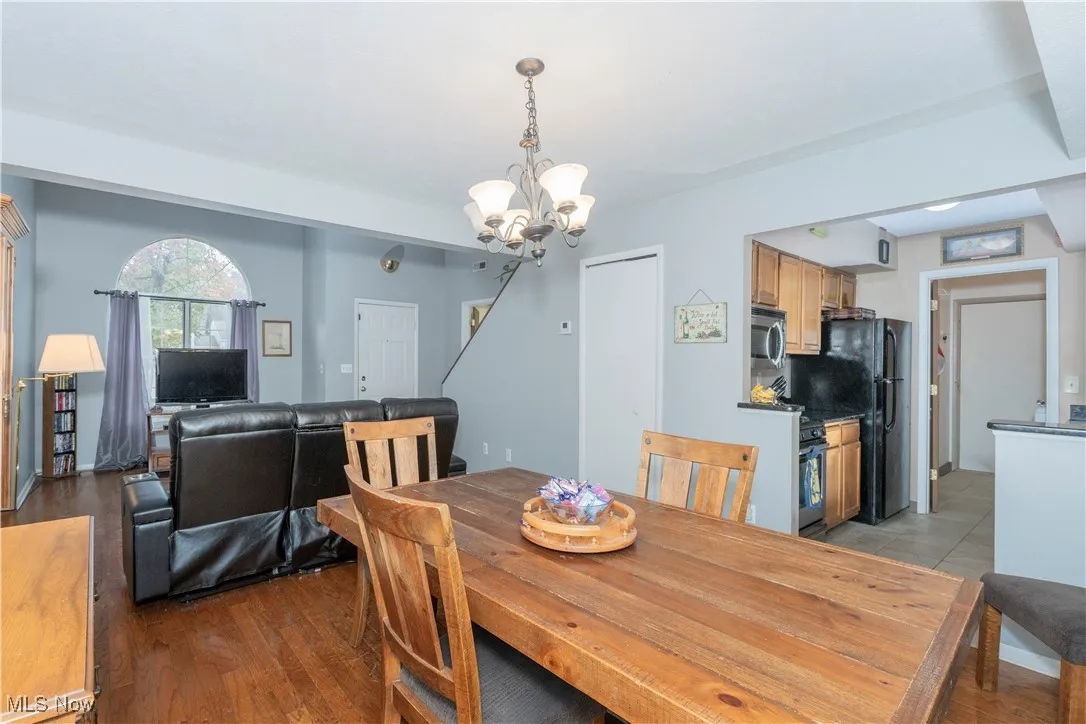 Dining area featuring dark wood-style flooring and a chandelier
