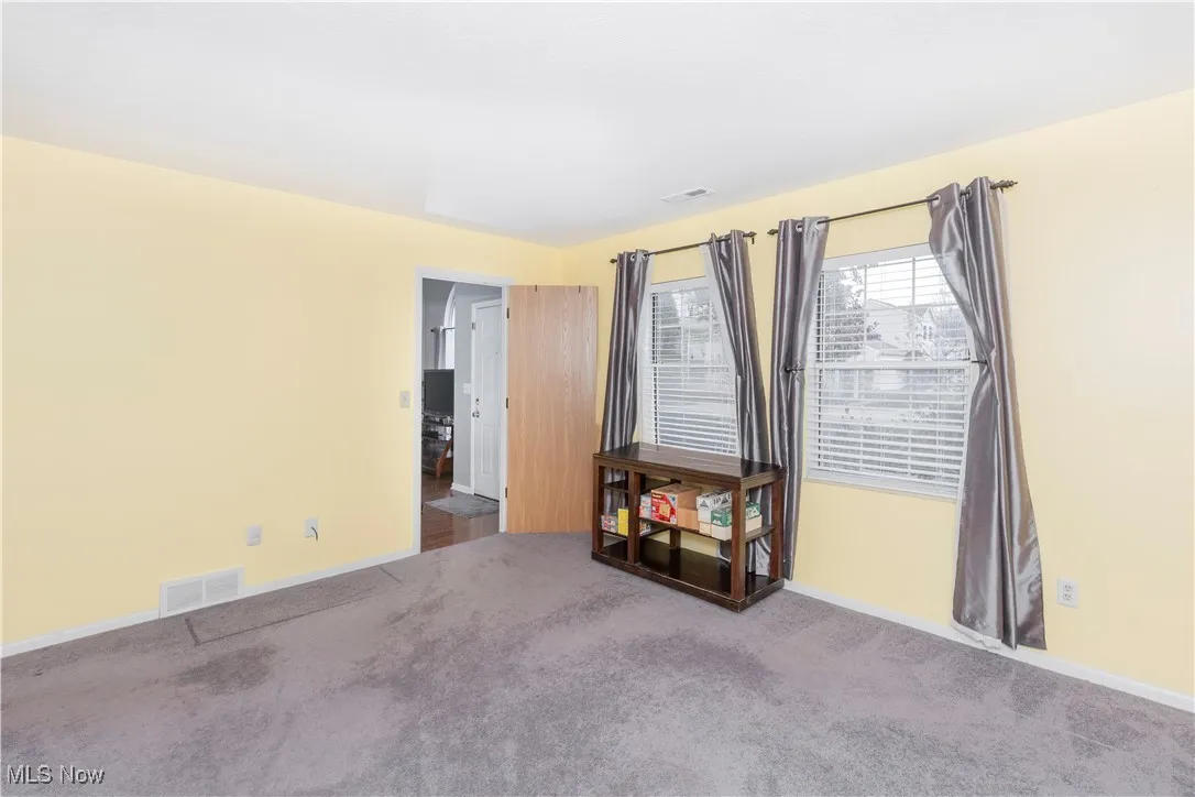 Carpeted spare room with baseboards