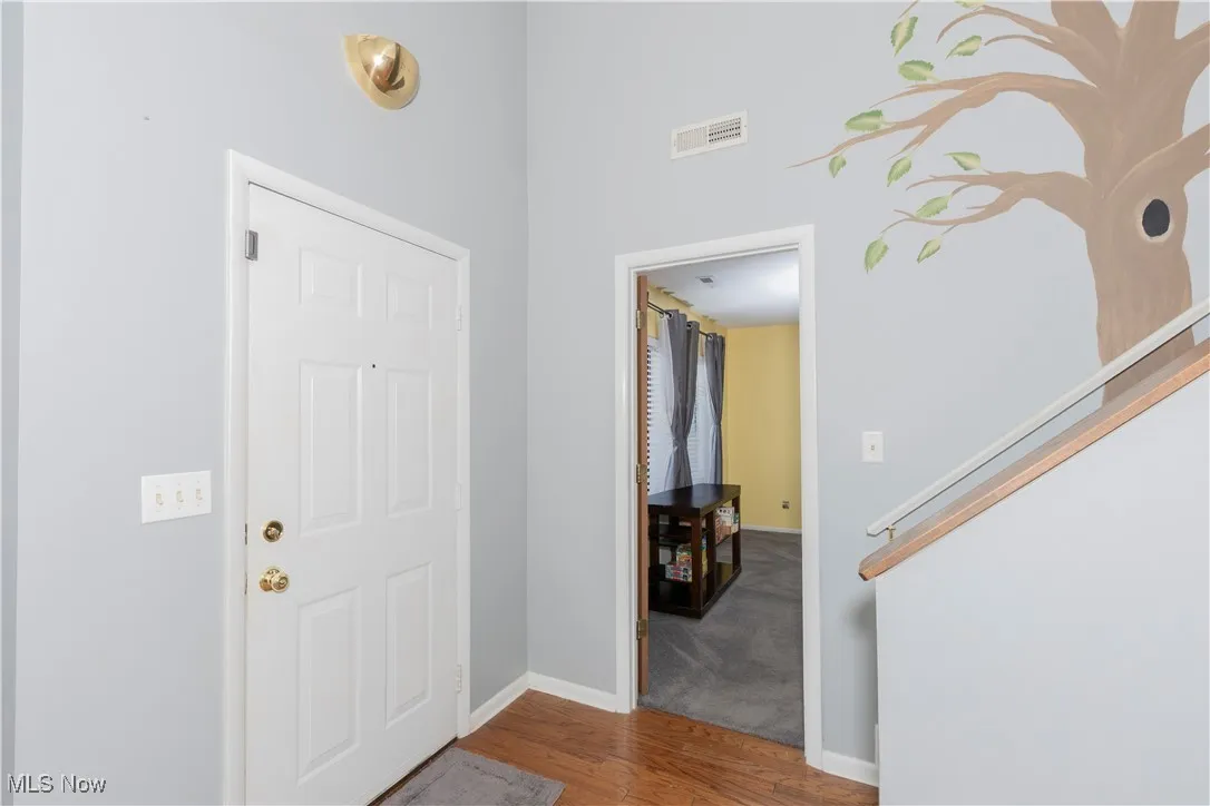 Entryway with wood finished floors and baseboards