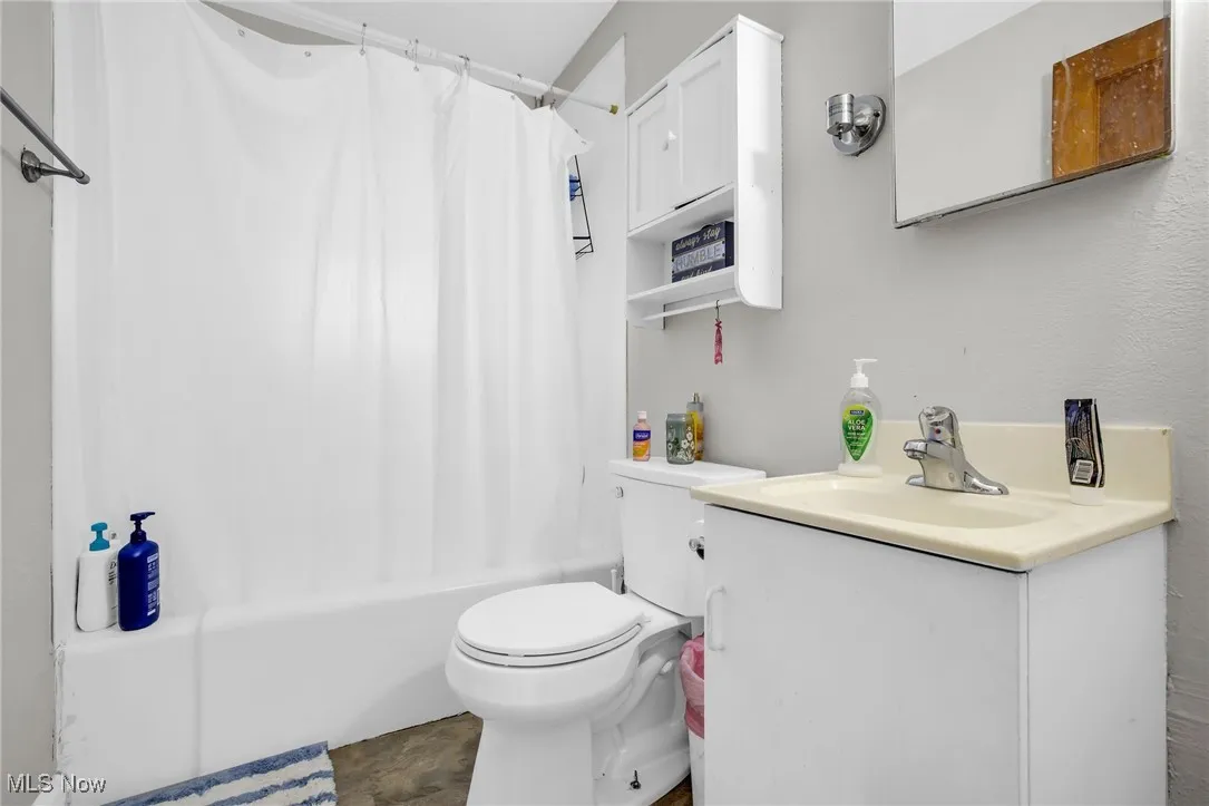 Full bathroom featuring shower / bath combination, toilet and vanity
