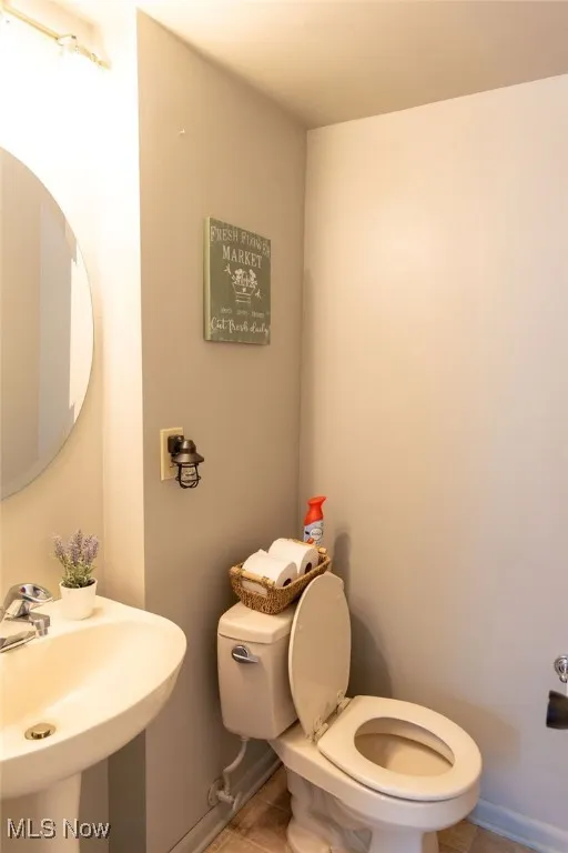 Half bath featuring toilet and tile patterned flooring