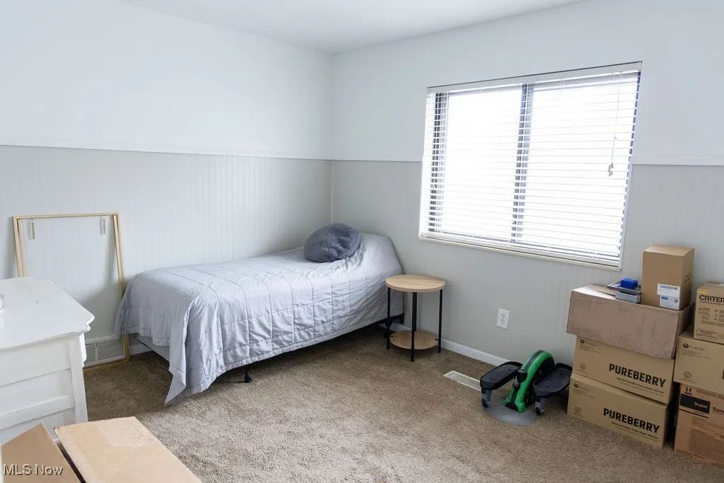 Bedroom featuring wainscoting and light colored carpet