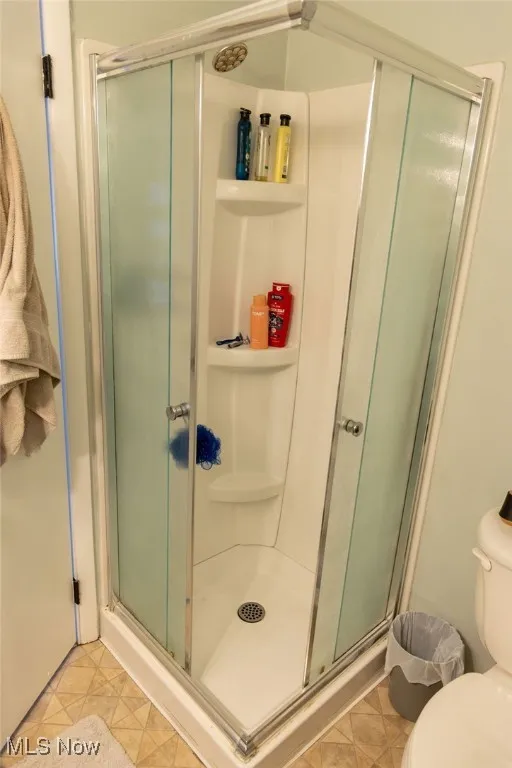 Full bath with a stall shower and toilet