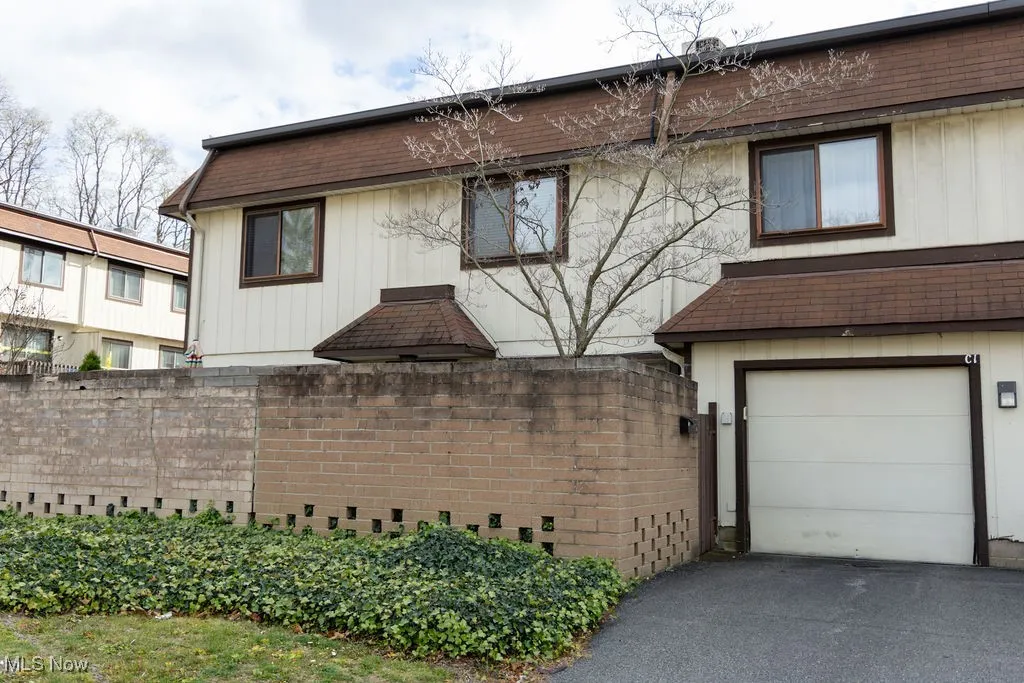 View of home's exterior featuring a garage, a shingled roof, and driveway