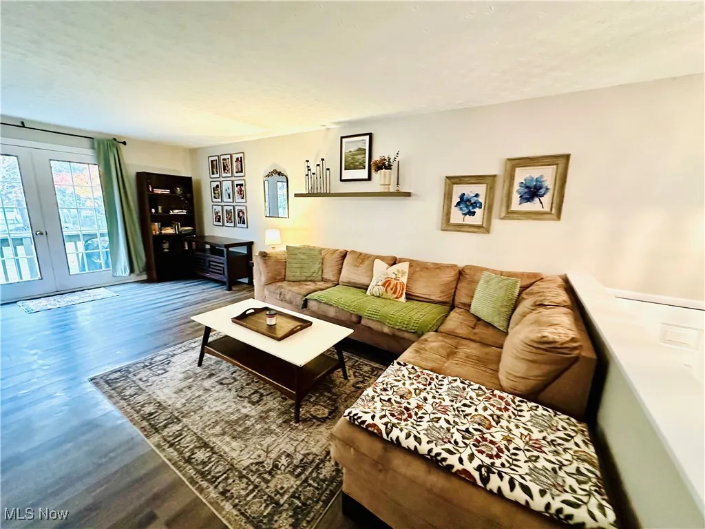 Living area featuring french doors, wood finished floors, and a textured ceiling