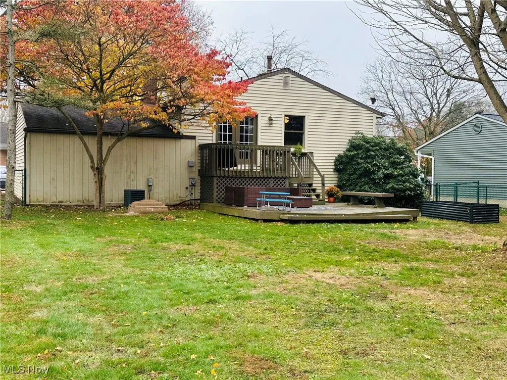 Back of house featuring a lawn and a deck
