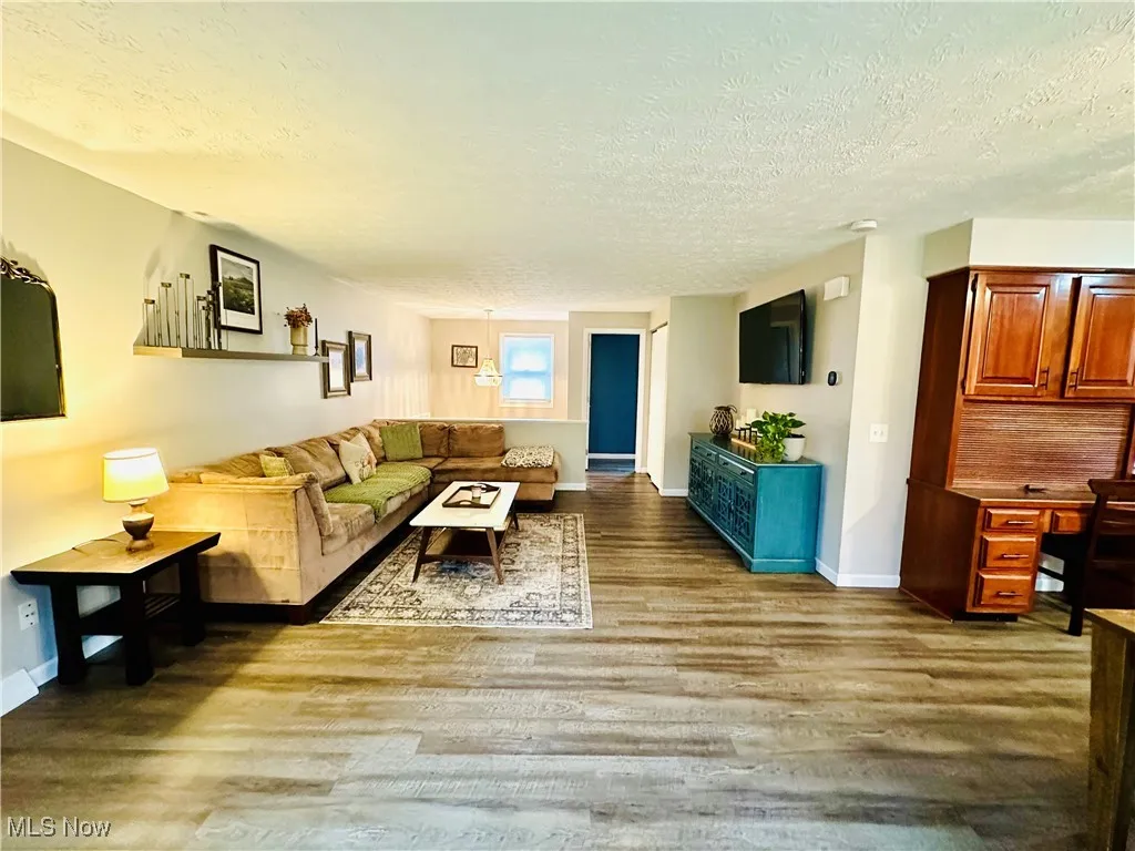 Living area with a textured ceiling and light wood finished floors