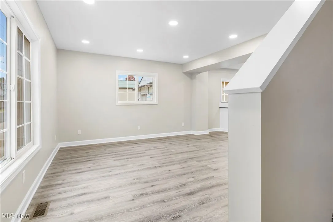 Below grade area with light wood finished floors and recessed lighting
