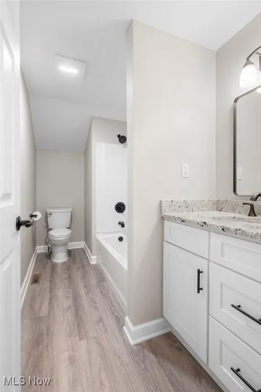 Full bathroom featuring vanity, light wood-style floors, and shower / washtub combination