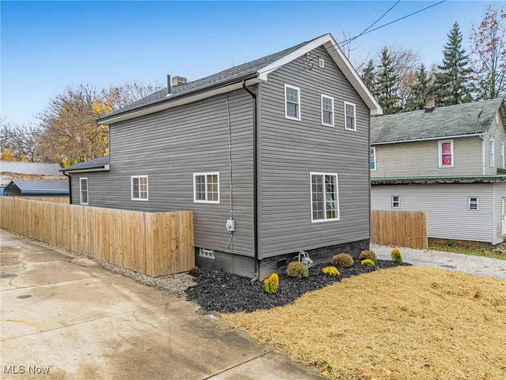 View of side of home featuring roof with shingles