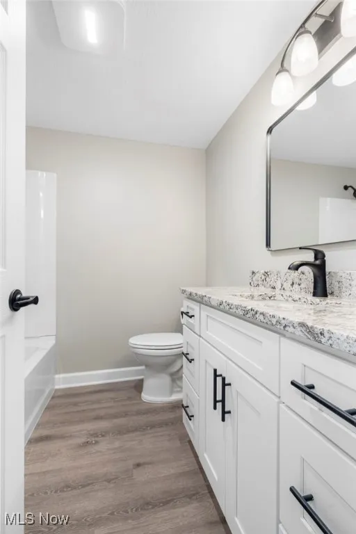 Full bath featuring vanity, dark wood-style floors, and shower / washtub combination