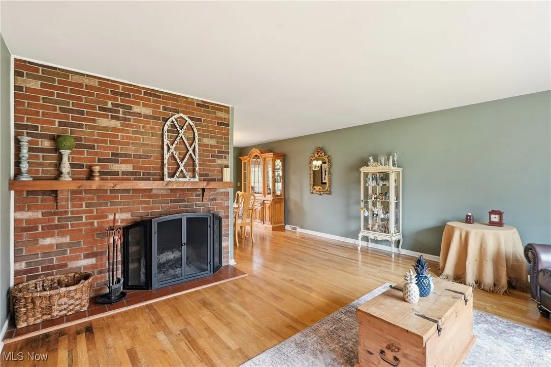 Living room featuring a brick fireplace and hardwood / wood-style flooring