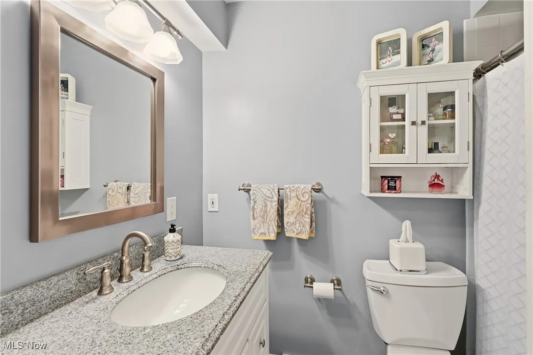 Full bathroom featuring curtained shower and vanity