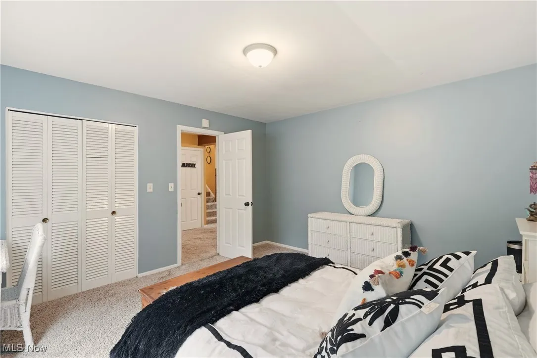 Carpeted bedroom featuring a closet and baseboards