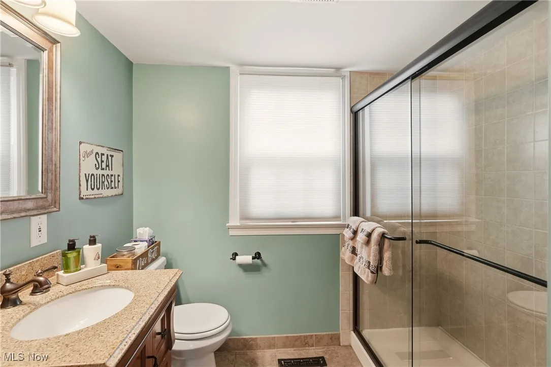 Bathroom with vanity, a stall shower, and tile patterned flooring