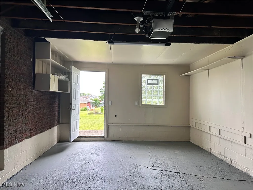 Garage with a garage door opener and door to back patio