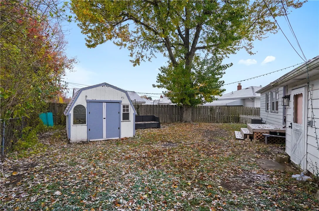 Fenced backyard featuring a shed