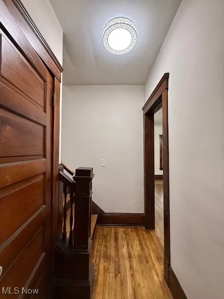 Corridor featuring wood finished floors and baseboards