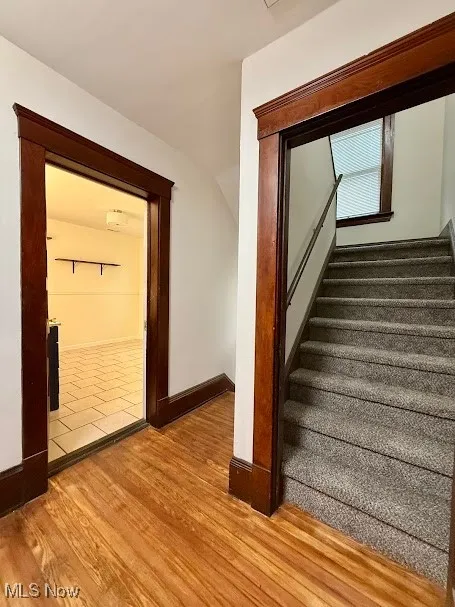 Stairs featuring wood finished floors and baseboards