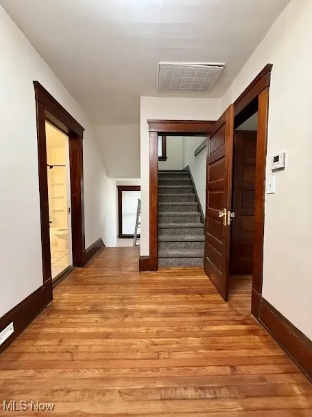 Hall with hardwood / wood-style flooring and stairway