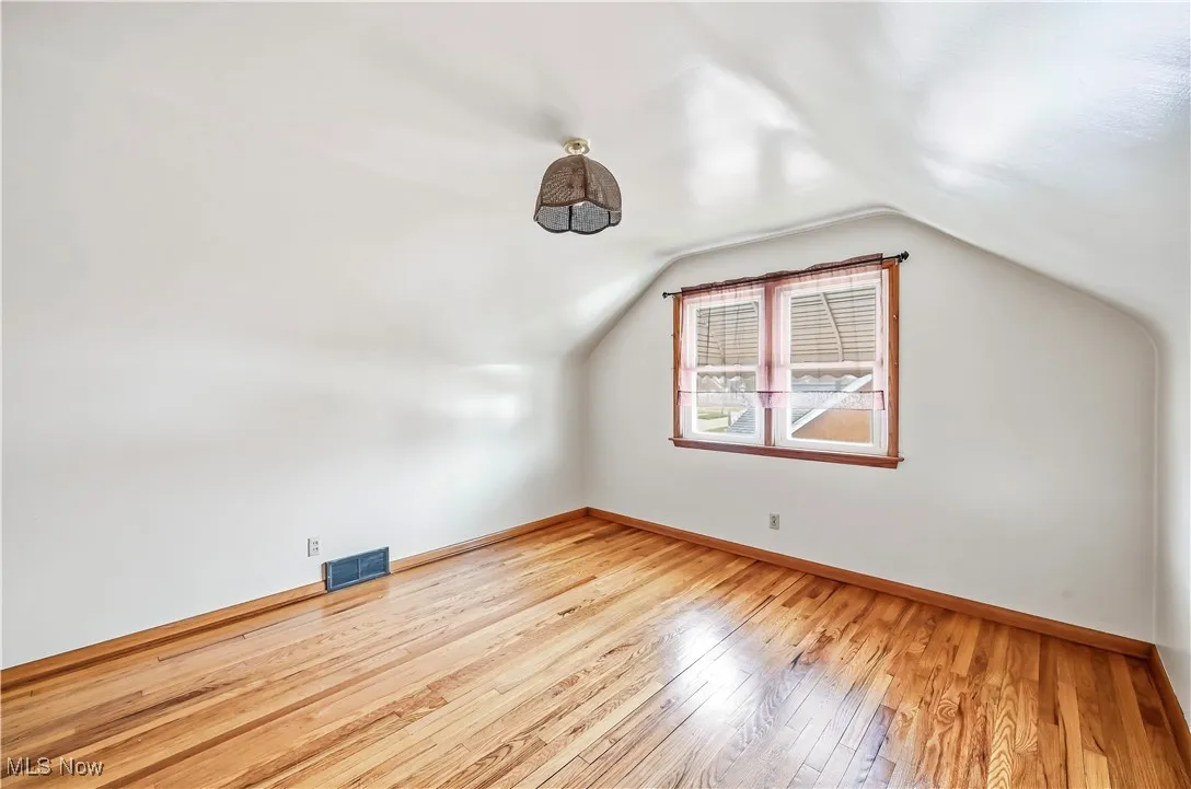 Bonus room featuring light wood-style flooring and lofted ceiling