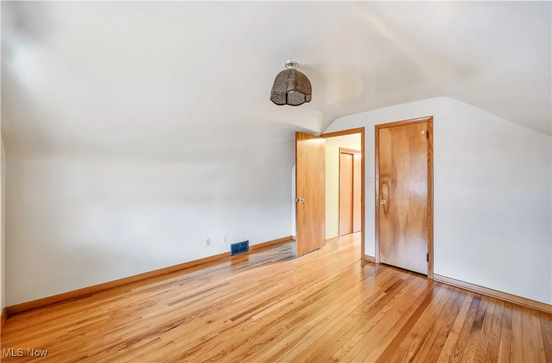 Additional living space featuring lofted ceiling and light wood-type flooring