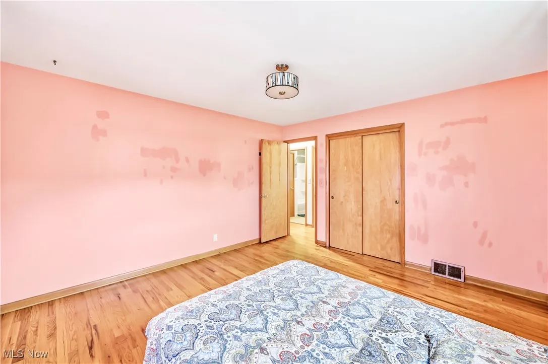 Bedroom with a closet and light wood finished floors