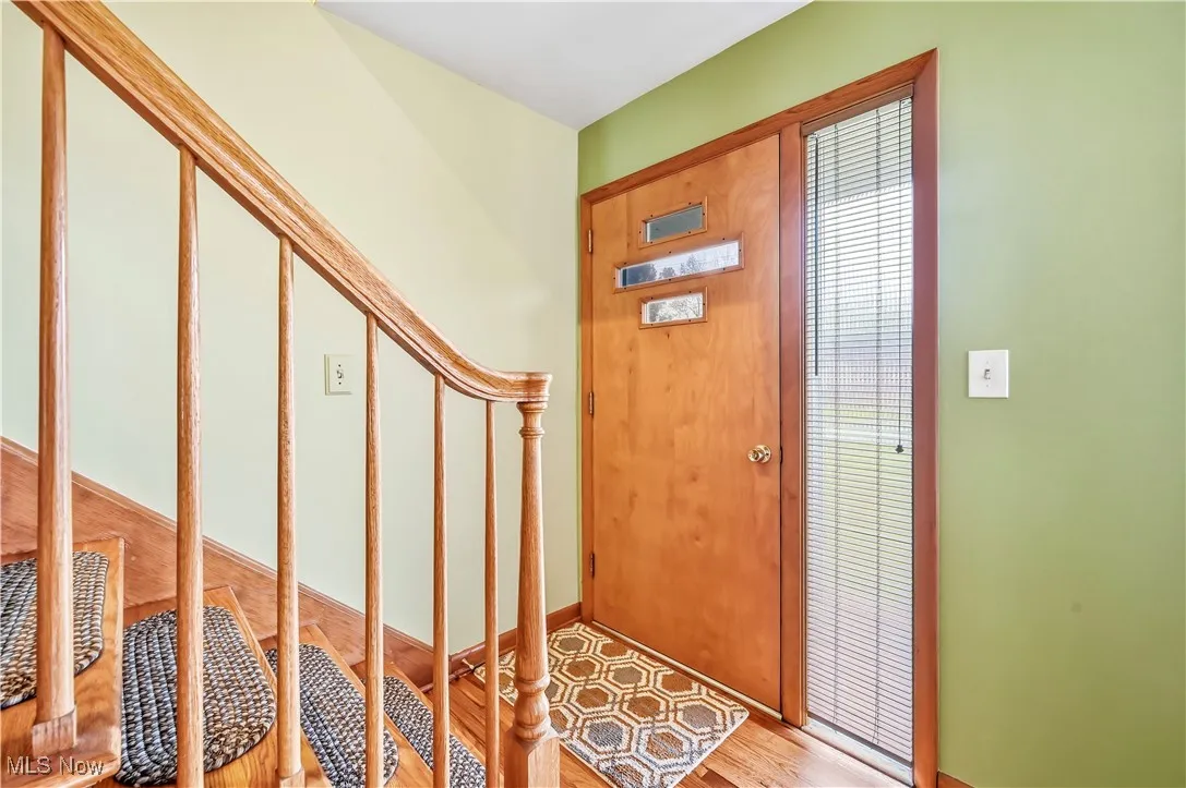 Foyer featuring stairs and light wood-style flooring