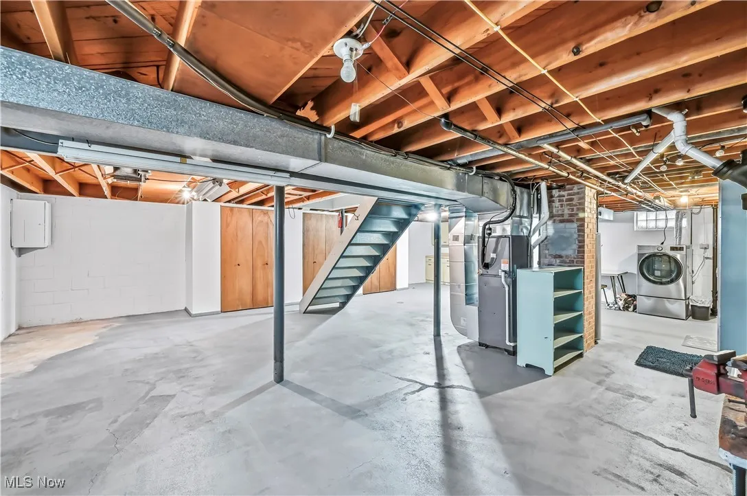 Unfinished below grade area with stairway, washer / clothes dryer, and heating unit