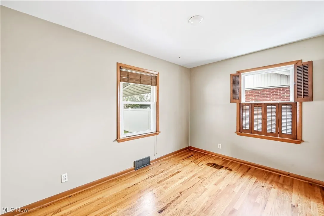 Unfurnished room with light wood-style floors and baseboards