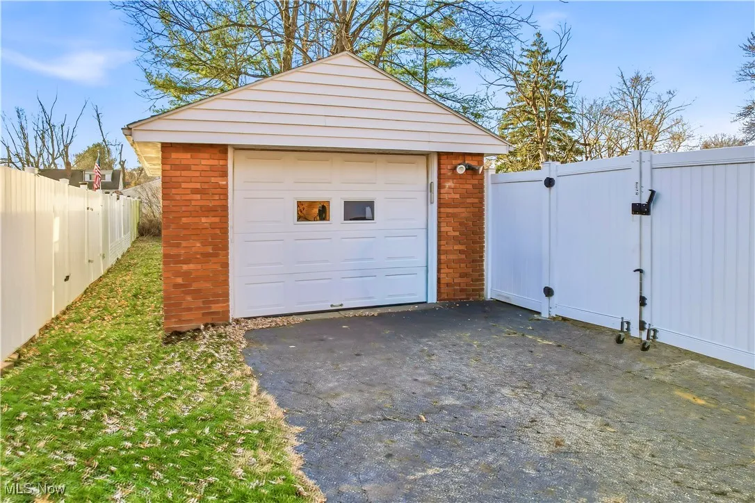Detached garage featuring driveway and a gate