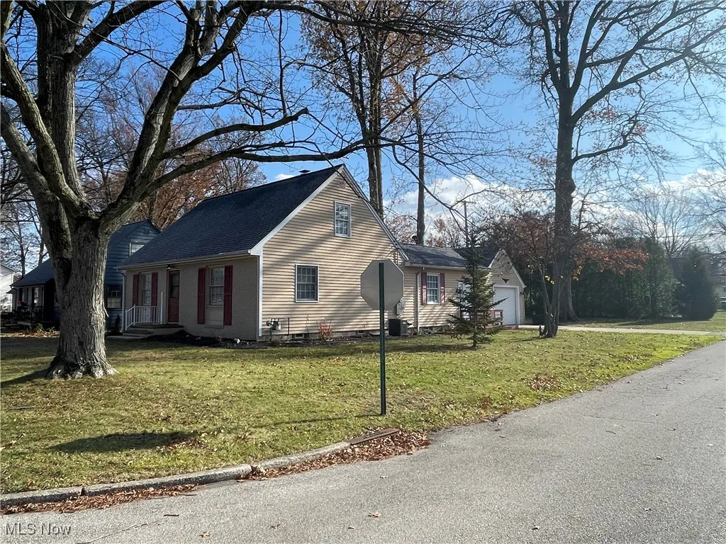 View of home's exterior featuring a lawn and attached garage