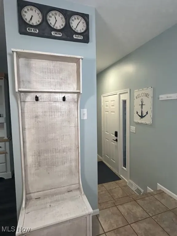 Mudroom featuring baseboards and tile patterned flooring