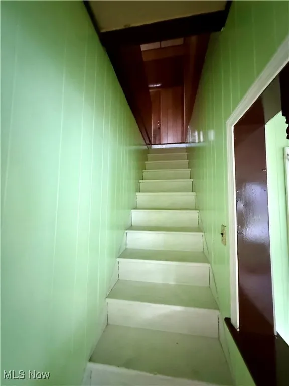 Stairway featuring wood walls