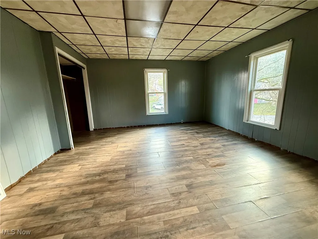 Spare room featuring wood finished floors and wood walls