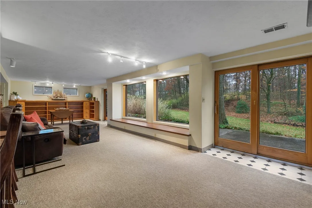 Carpeted living area with a textured ceiling and rail lighting