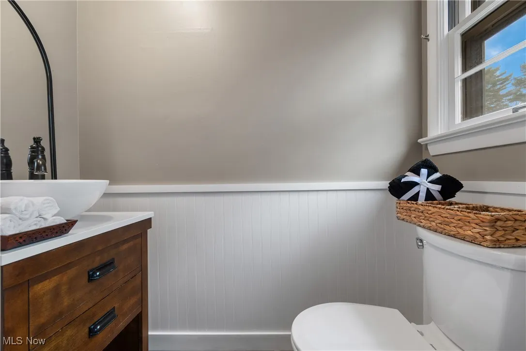 Bathroom with a wainscoted wall and vanity