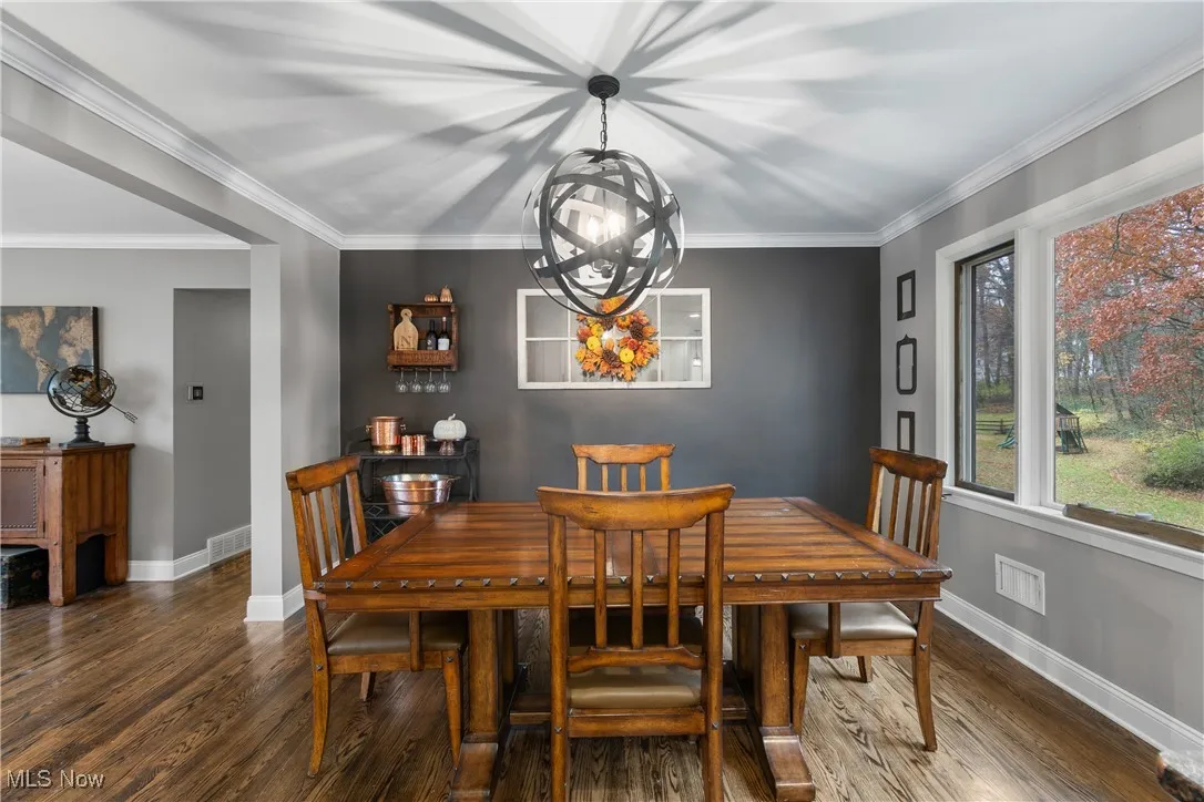 Dining area with dark wood finished floors and a chandelier